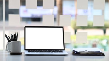 Bilgisayarlı modern çalışma alanı, belgeler ve kahve fincanı beyaz masada..