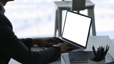 Ofiste çalışırken bilgisayarlı laptop kullanan işadamı iş verilerini tarıyor.