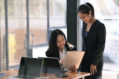 Modern ofiste yatırım oranını inceleyen ve analiz eden iki başarılı iş kadını.