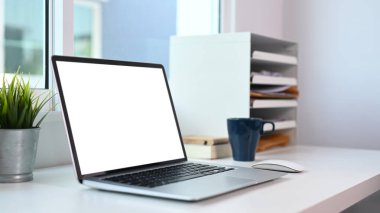 Modern ofis masasında boş ekranı olan bilgisayar dizüstü bilgisayarının görünümünü kapat.