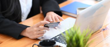 Kredi kartı alışverişi yapan iş kadınının yatay fotoğrafı ya da bilgisayar laptopuyla online ödeme yapan..