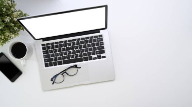 Bilgisayar, akıllı telefon, kahve fincanı ve beyaz arkaplan üzerine kopyalama alanının genel görüntüsü.