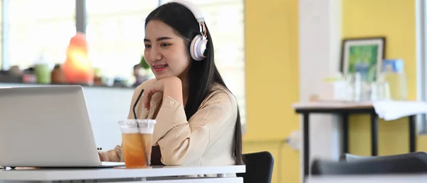 커피숍에 앉아서 헤드폰을 노트북 컴퓨터를 온라인 학습을 여학생의 — 스톡 사진