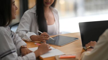 Modern ofis üzerinde ahşap toplantı masasında otururken iş geliştirme ekibi toplantısı / çalışması / konuşması / tartışması fotoğrafı.