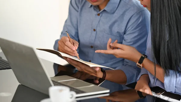 Cropped image of business developer team discussing/talking/working together with computer tablet, laptop and document while sitting at the modern working desk over comfortable office as background.