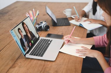 Kesilmiş görüntüler arkadaşlarıyla bilgisayar ve tabletin önünde otururken video görüşmesi yapıyor..