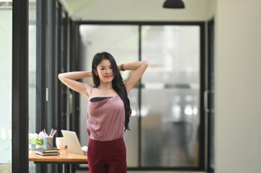 Güzel bir kadın çalışma masasında dinlenirken kolunu uzatıyor..