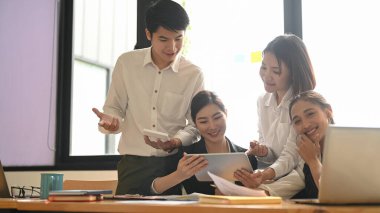 İş adamları ahşap masada bilgisayar ve tabletle birlikte çalışıyorlar..