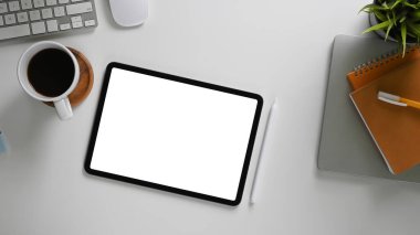 Beyaz ekranlı bir bilgisayar tabletinin en üst görünümü çalışma masasına rahat bir görüntü koyuyor.