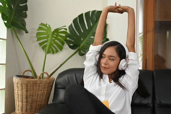 Uma Mulher Bonita Está Relaxando Ouvindo Música Enquanto Senta Sofá — Fotografia de Stock