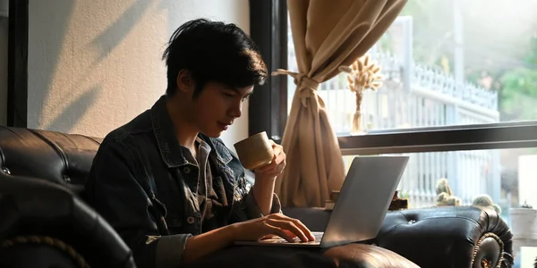 Foto Hombre Inteligente Usando Portátil Sosteniendo Una Taza Café Las — Foto de Stock