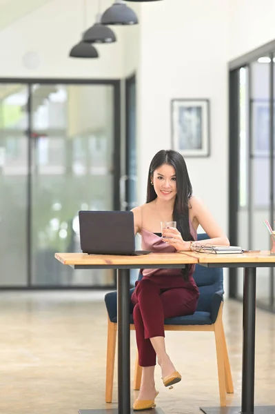 Güzel Bir Asyalı Kadın Ahşap Çalışma Masasında Bilgisayarın Önünde Oturuyor — Stok fotoğraf