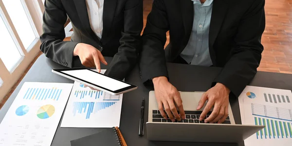 Cropped image of business development team meeting/talking about their new business project result while sitting together at meeting table over comfortable office as background.