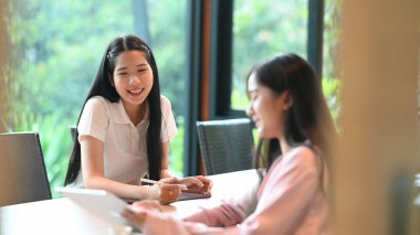 Güzel bir kadın toplantı odasında otururken bilgisayar tableti ve stil kalemi kullanıyor..