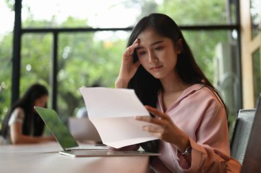 Bir iş kadını toplantı odasında otururken evrakları kontrol ediyor..