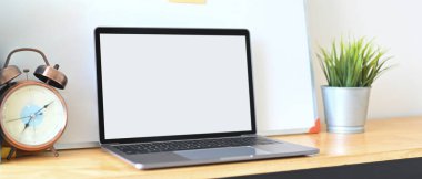 Bilgisayar dizüstü bilgisayar, çeşitli ekipmanlarla çevrili ahşap bir çalışma masasına yerleştiriyor..