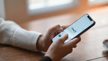 LinkedIn uygulamalı akıllı telefonu ekranda tutan kadın elleri