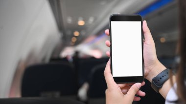 Kesilen eller uçakta beyaz boş bir ekran akıllı telefon kullanıyor..