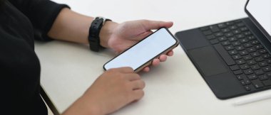 Beyaz ekranlı telefon kullanan ellerin kırpılmış görüntüsü 