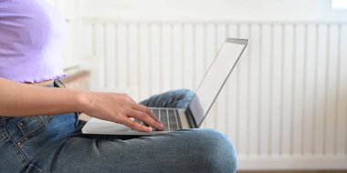 Kadının dizüstü bilgisayarını kullanırken çekilmiş görüntüsü.