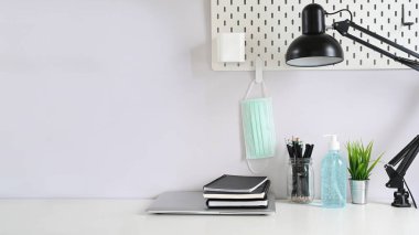 Ofis masası ofis malzemeleri ve COVID 19 önleme öğesi bir masada, salgın konsepti sırasında çalışma alanı.