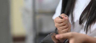 Kesilmiş bir genç akıllı telefonu şarj ediyor.