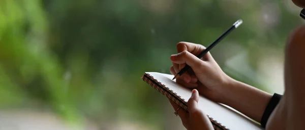 女商人用铅笔在笔记本上记笔记的剪影 — 图库照片