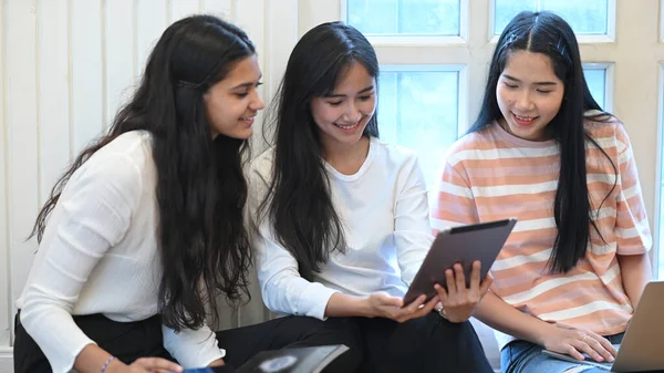 大学生通过使用电脑平板电脑参加网上学习小组 一起坐在客厅里靠窗的地板上作为背景 — 图库照片