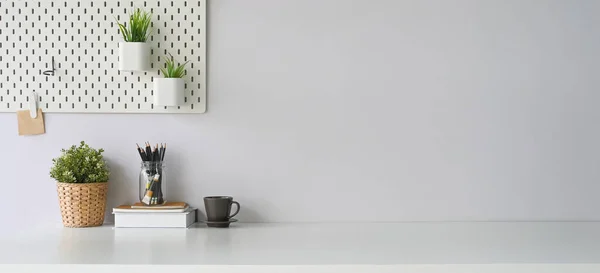 stock image workspace with coffee cup, diary, notebook, book, pencil holder, plant in wicker basket and potted plant on desk