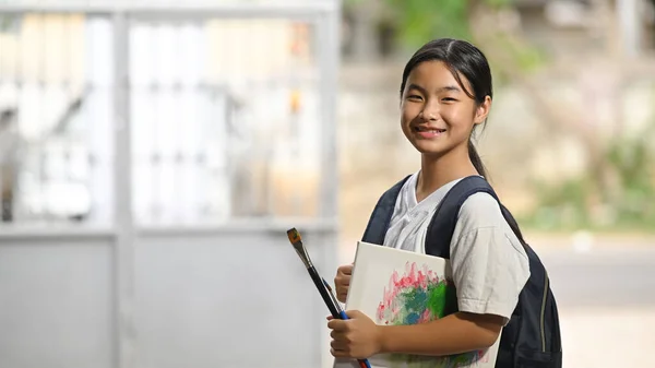 Een Schoolmeisje Houdt Schilderspullen Vast Draagt Een Schooltas Terwijl Staat — Stockfoto