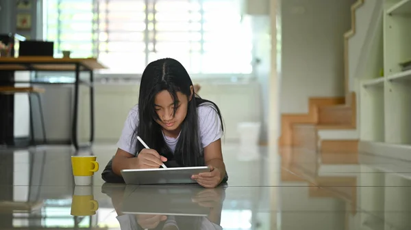 Ένα Μικρό Κορίτσι Χρησιμοποιεί Ένα Tablet Υπολογιστή Και Στυλό Ενώ — Φωτογραφία Αρχείου