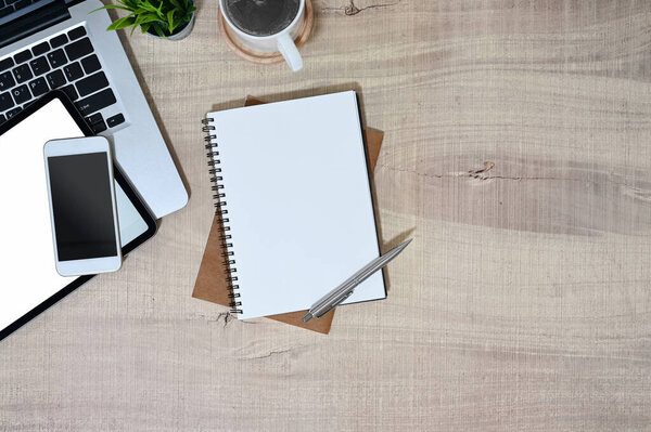 The top view image of a workspace is surrounding by a notebook and various equipment.