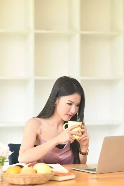 Uma Mulher Está Segurando Uma Xícara Café Suas Mãos Enquanto — Fotografia de Stock