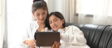 LeBT Asya çifti dijital tabletle rahatlayan kadın..