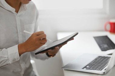 Dijital tablet ve Stylus kalemle çalışan kırpılmış yaratıcı adam..