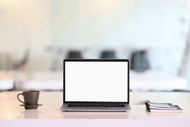 Laptop bilgisayarı, kahve ve iş yeri ile ilgili toplantı odası geçmişi bulanık olan not defteri..