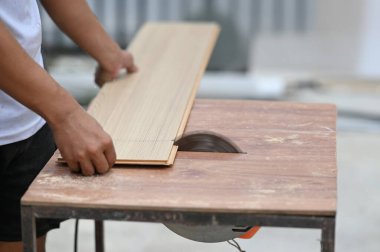 Ahşap tezgahta ekipmanla çalışan bir marangozun yakın çekimi..