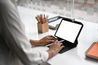 Cropped shot woman typing mockup tablet computer with blank screen.	