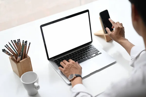Kadınının Yerinde Beyaz Ekranlı Akıllı Telefon Laptop Kullanırken Görüntüsü Kesilmiş — Stok fotoğraf