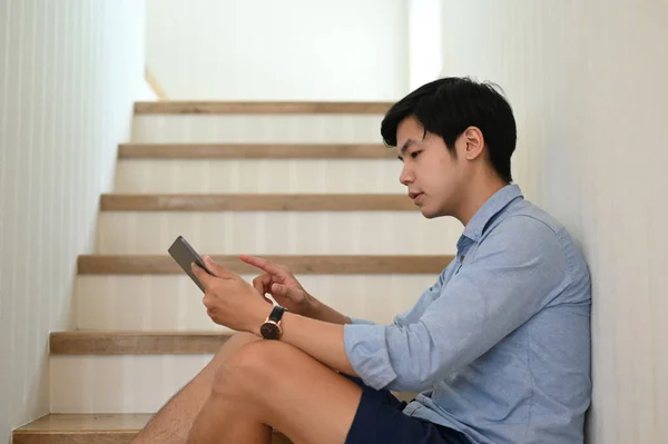 Όμορφος Νεαρός Άνδρας Που Χρησιμοποιεί Tablet Ενώ Κάθεται Μια Σκάλα — Φωτογραφία Αρχείου