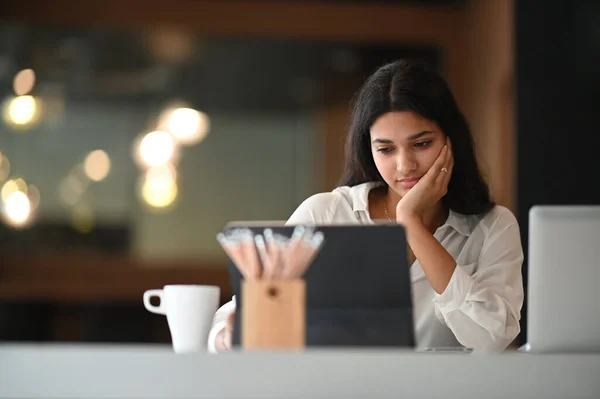 Μια Όμορφη Γυναίκα Κοιτάζει Την Οθόνη Tablet Υπολογιστή Ενώ Κάθεται — Φωτογραφία Αρχείου