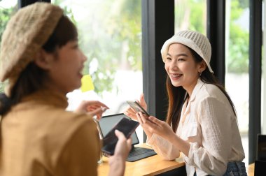 İyi ilişkileri olan ve iş yerinde yeni projeleri tartışan arkadaş canlısı bayan meslektaşlar. .