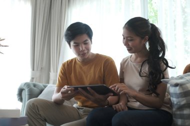 Mutlu evli çift hafta sonu tatillerini evde tabletle geçiriyor..