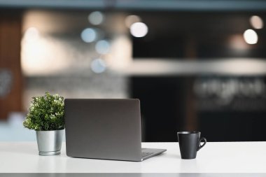 Modern workspace with computer laptop and decorations on white table.
