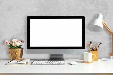 Front view of workspace with blank computer screen for graphic display montage.