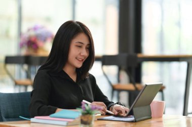 Ofiste çalışırken stilus kalemle dijital tablet üzerinde çalışan iş kadınının portresi.