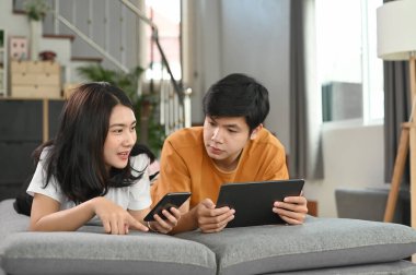 Evde internette sörf yaparken kanepede uzanan çekici sıradan bir çift..