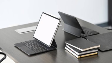 Dark modern workspace with mock up empty screen tablet on black desk.