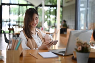 Ofiste cep telefonundan video izleyen kadın ofis çalışanının portresi.