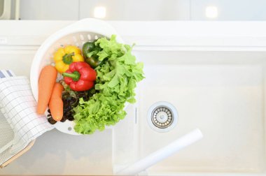 Top viwe of colorful vegetables in  bowl on sink at modern kitchen.